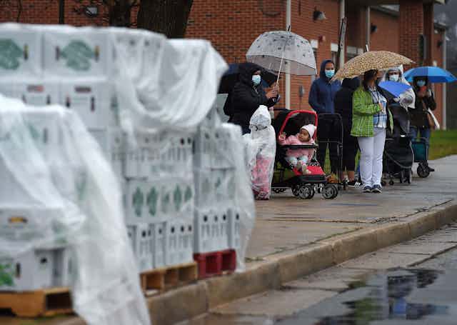 People wait in a line outside a food distribution center in Cockeysville, Maryland.