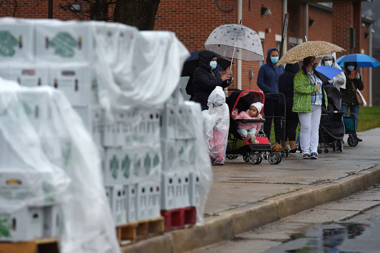 People wait in a line outside a food distribution center in Cockeysville, Maryland.