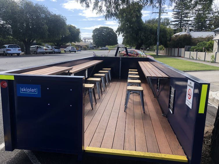 tables and chairs in a pop-up 'skiplet' set up in a parking space