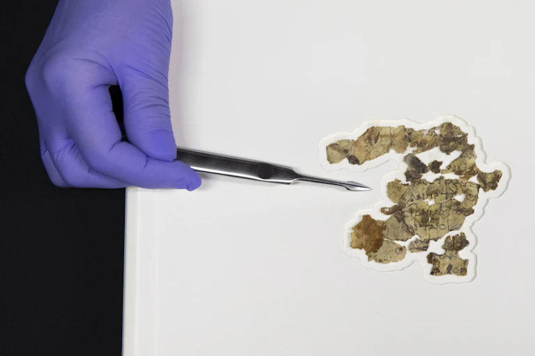 gloved hand and ancient fragments of paper