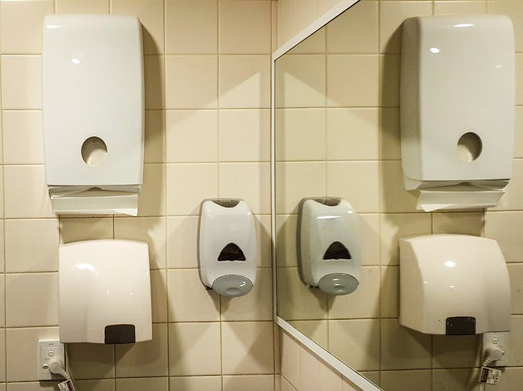 Bathroom wall with both paper towels and air dryer.