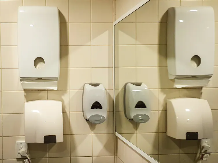 Bathroom wall with both paper towels and air dryer.