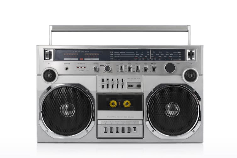 A silver boombox with a cassette tape holder in the middle