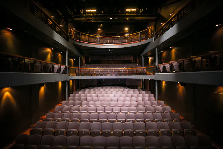 An empty theatre, lights shining on rows of old seats, an air of vintage.