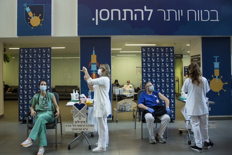 Nurses prepare to give medical workers vaccines.