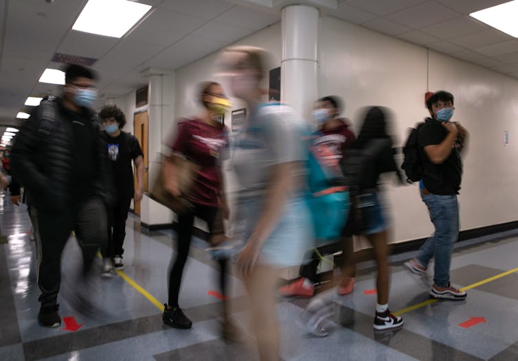 High school students pass each other in hallway