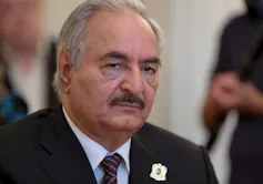 A man with a moustache and suit and tie