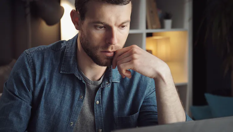 Young man looking at computer screen.