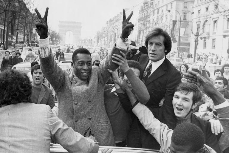 Pele flashes victory signs.