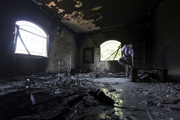 A man looks at the ruins of the U.S. Consulate building