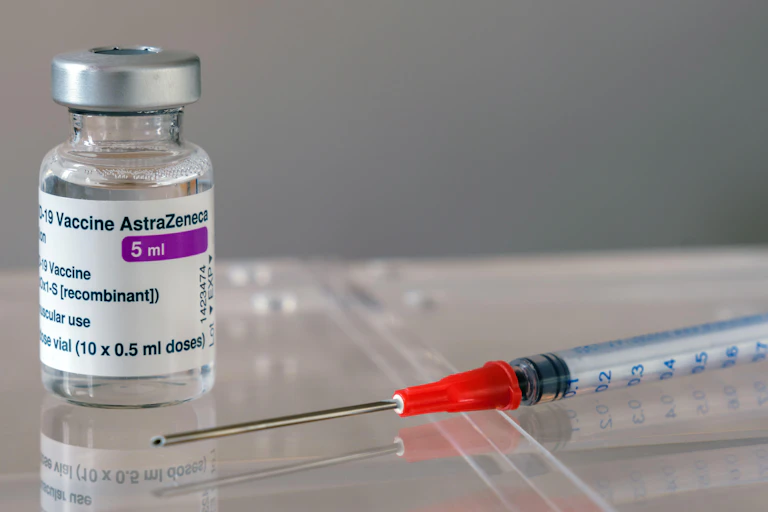 A vial of vaccine and a needle.