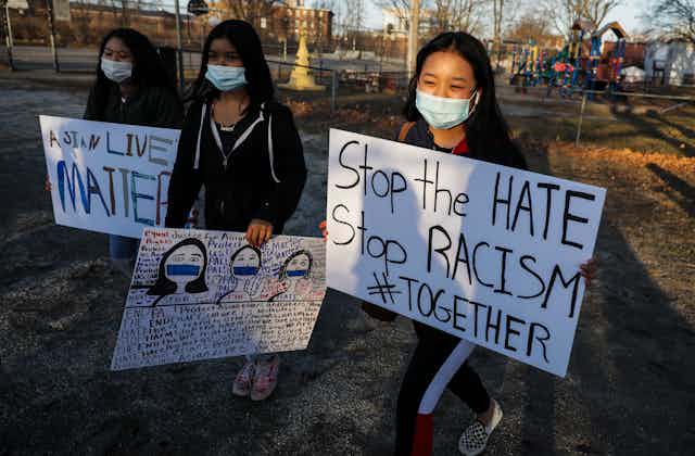 Children in a vigil holding signs that say "Asian Lives Matter" and "Stop the Hate"
