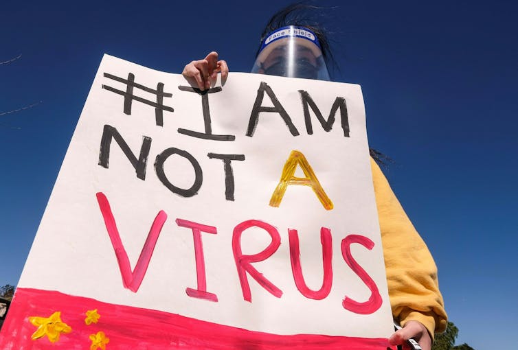 A woman holding a sign that says