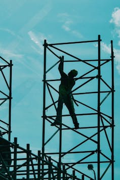 A worker standing on scaffolding.