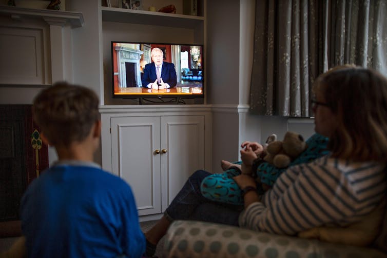 A family watches Boris Johnson on TV