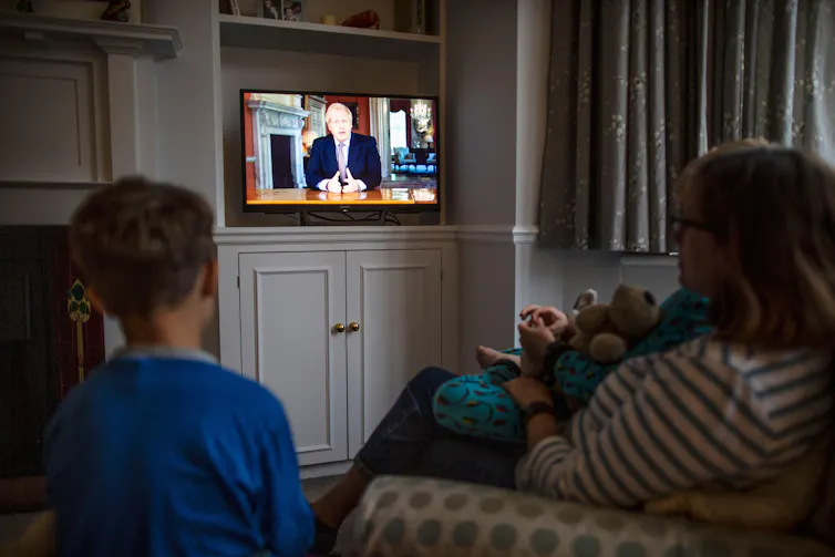 A family watches Boris Johnson on TV
