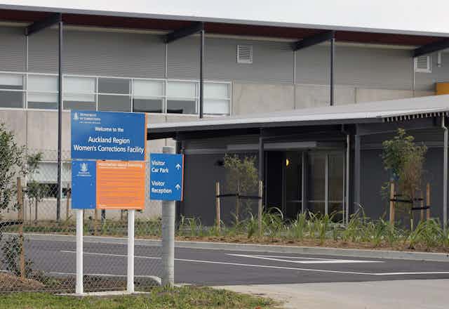 Exterior of prison with signs reading Auckland Women's Correction Facility
