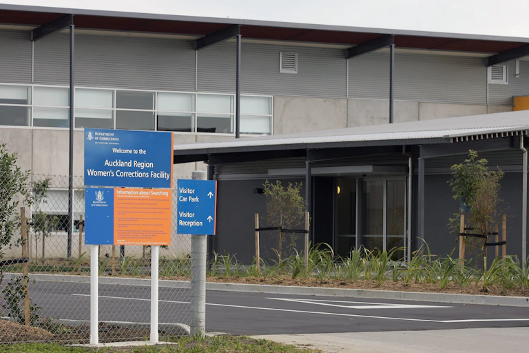 Exterior of prison with signs reading Auckland Women's Correction Facility