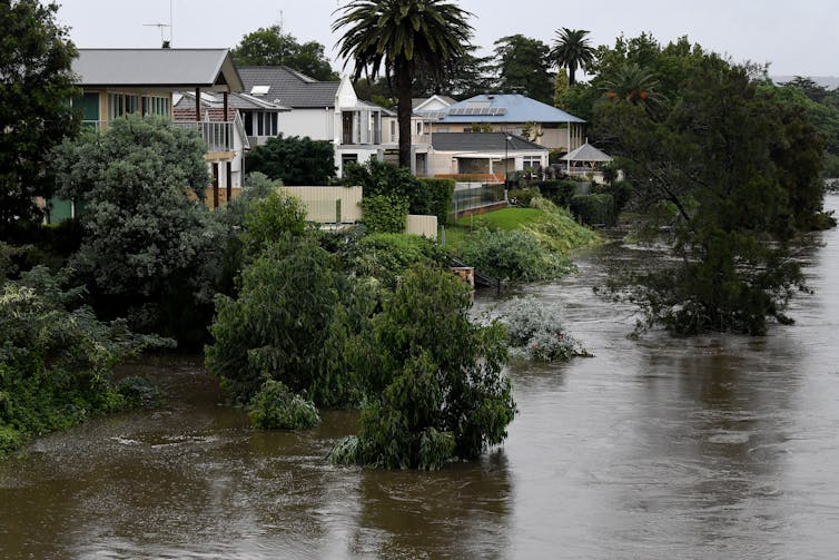 Properties are seen as the Nepean River overflows in Penrith. Rivers are bursting their banks, dams are overflowing and many NSW residents are on standby to leave their homes as heavy rain continues to pelt the state.