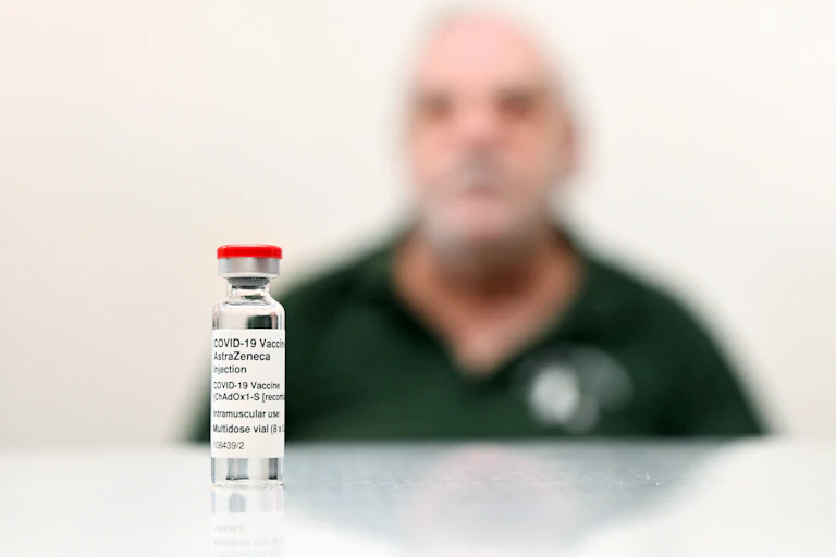 A vial of the AstraZeneca vaccine in front of a patient