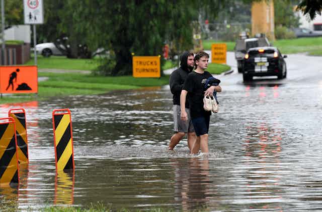 People walk through floodwaters.