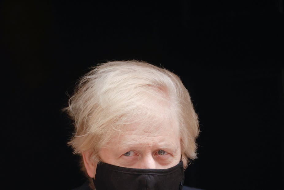 Boris Johnson leaving Downing Street wearing a face mask.
