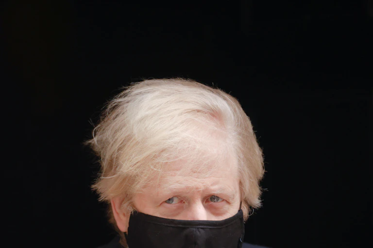 Boris Johnson leaving Downing Street wearing a face mask.