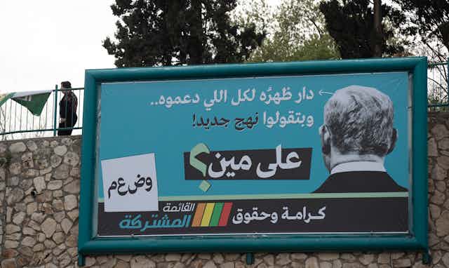 Large billboard showing the back of the prime minister, Benjamin Netanyahu's head and a an anti-Netanyahu message in message in Arabic script.