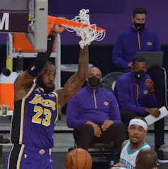 Joueur de basket se suspend au panier.