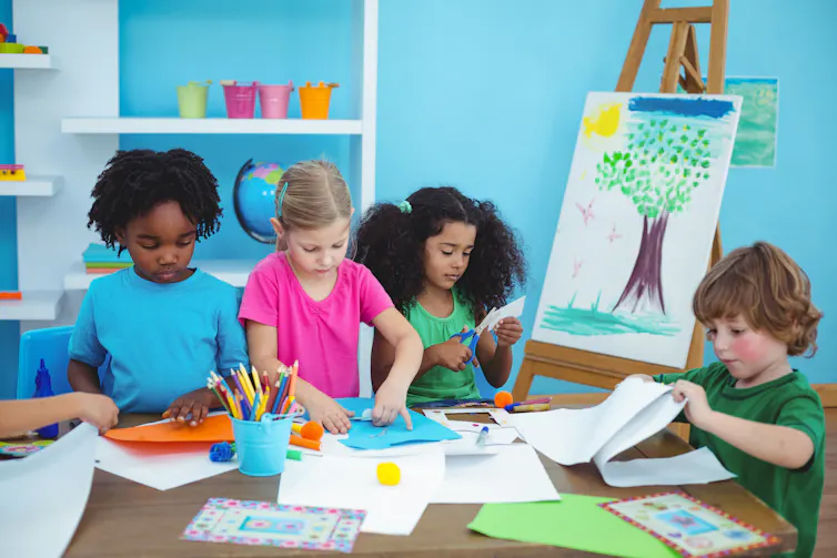 Four children painting and drawing.