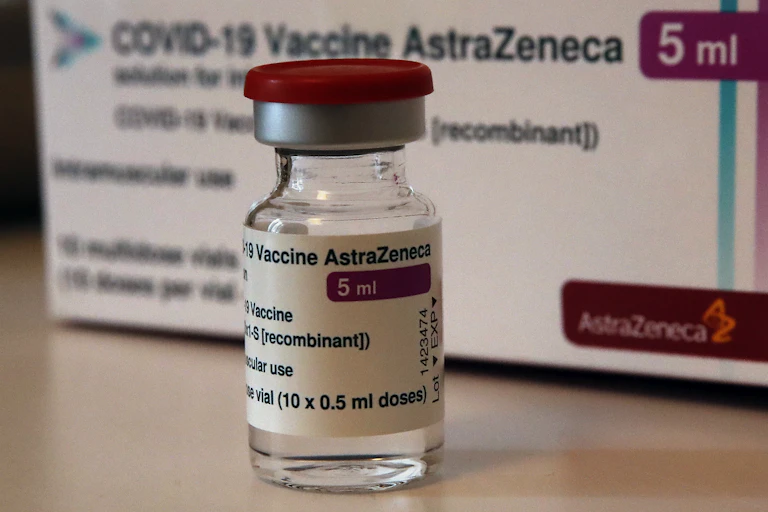 A vial of the AstraZenaca vaccine in front of a box.