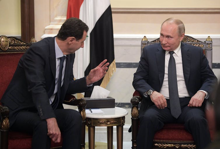 Bashar as-Assad and Vladimir Putin seated and talking