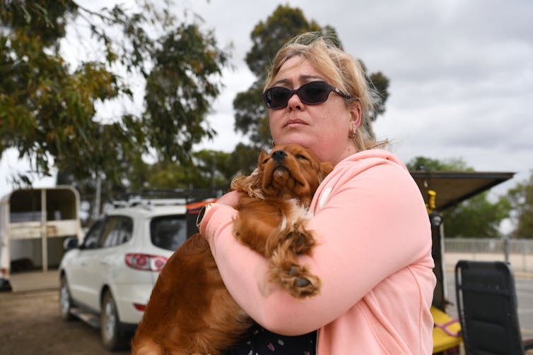 woman holds dog