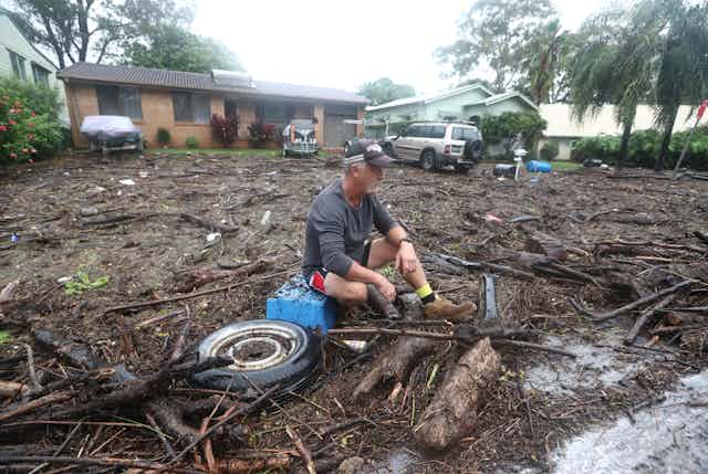 man looks at flood damage