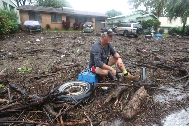 man looks at flood damage