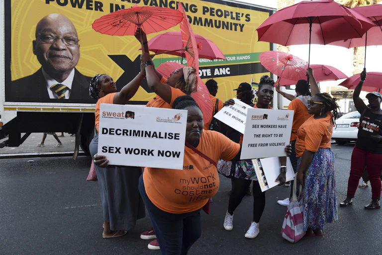 Protesters holding placards and umbrellas