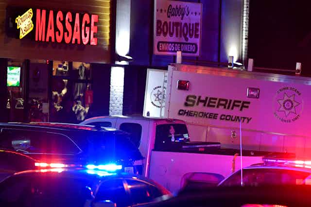 A police van sits outside an Atlanta-area massage parlor.