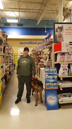 A war veteran with a service dog, in a supermarket aisle