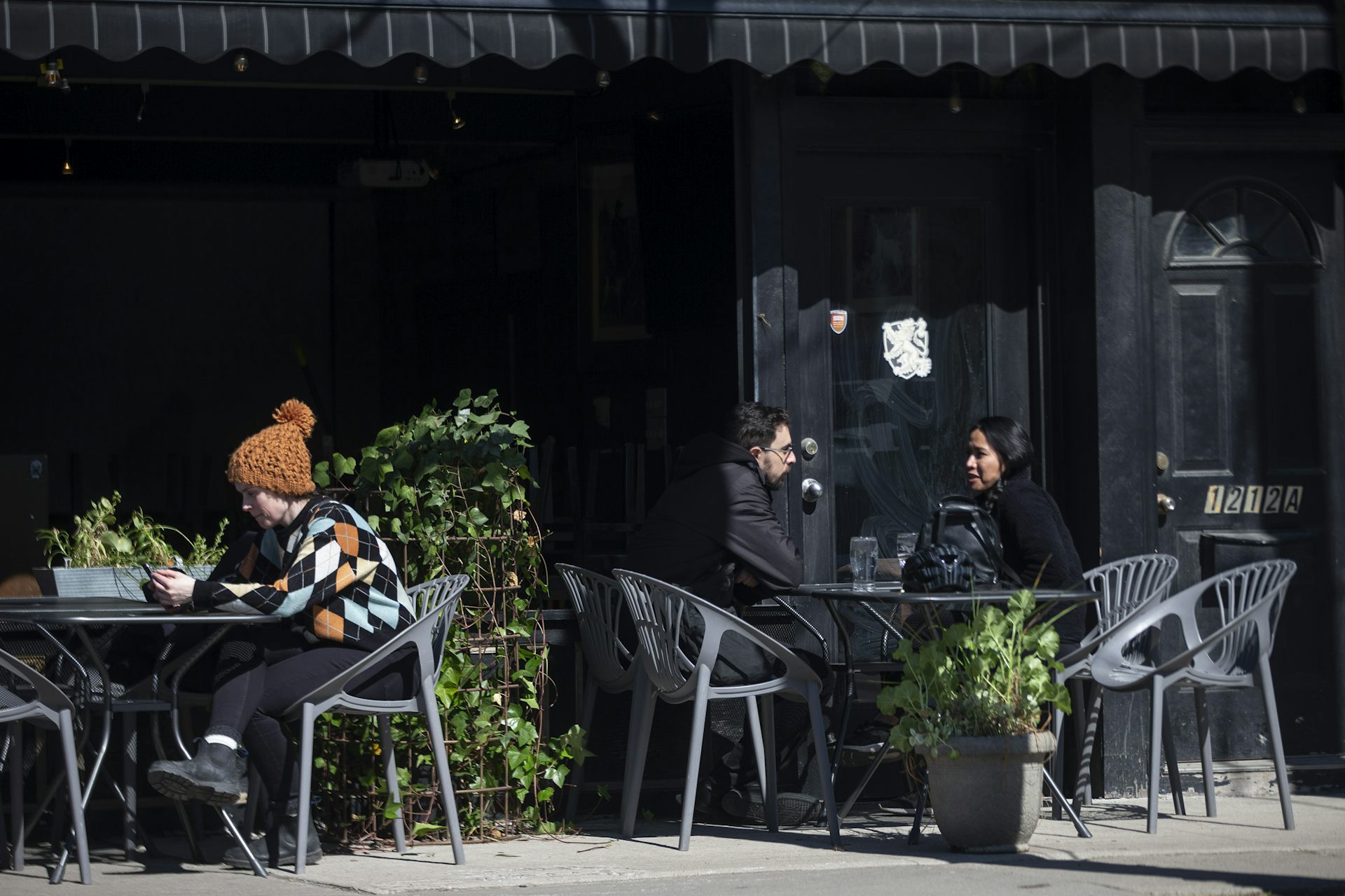 Customers sit on a patio at a bar.