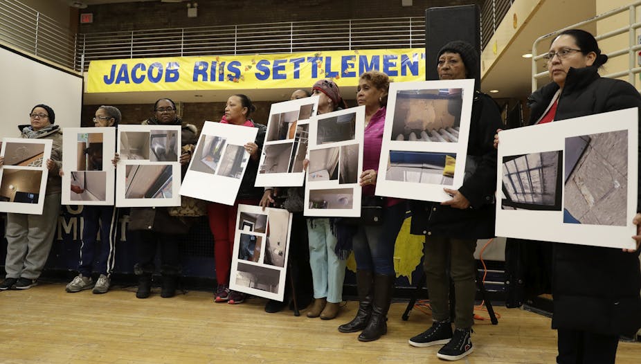 People display posters showing damaged  in public housing.