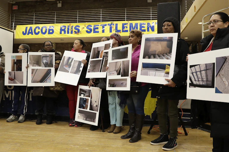 People display posters showing damaged in public housing.