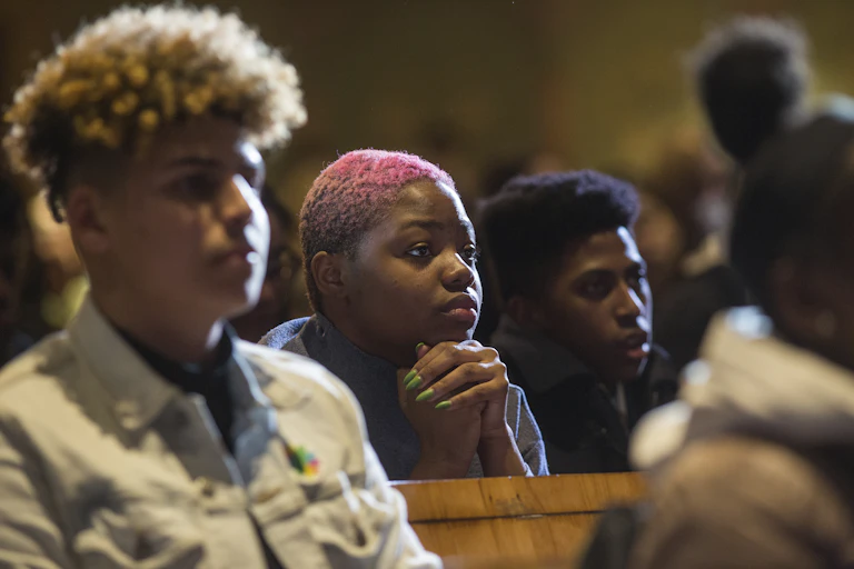 Teenagers sit together in an audience