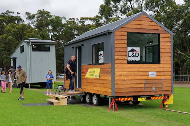 people inspecting a tiny house