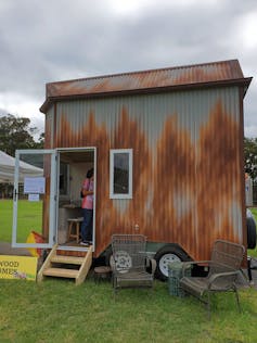 women looks inside a tiny house on display