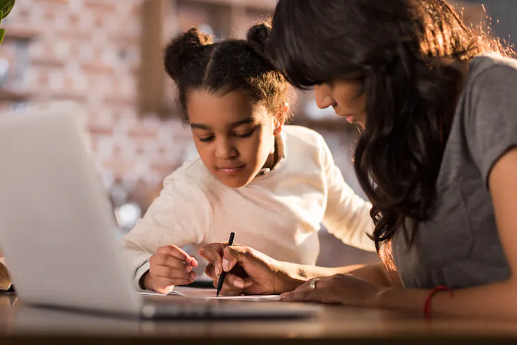 A woman and child working in front of a laptop