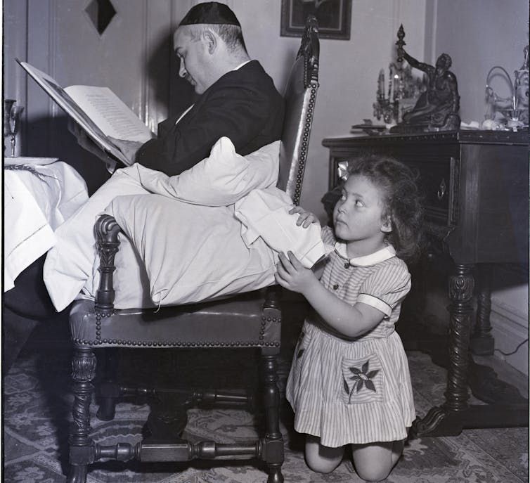 A young girl pretends she is'stealing' the bread, Afikomen, as part of Passover celebrations.