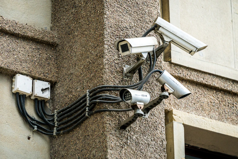 Four security cameras fixed to a wall, pointing left and right