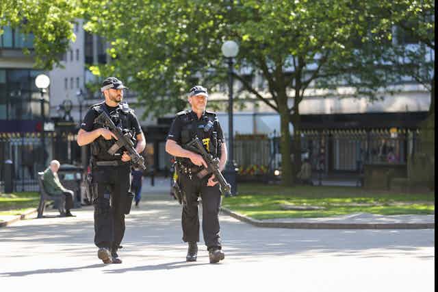 Two police officers carrying guns in park
