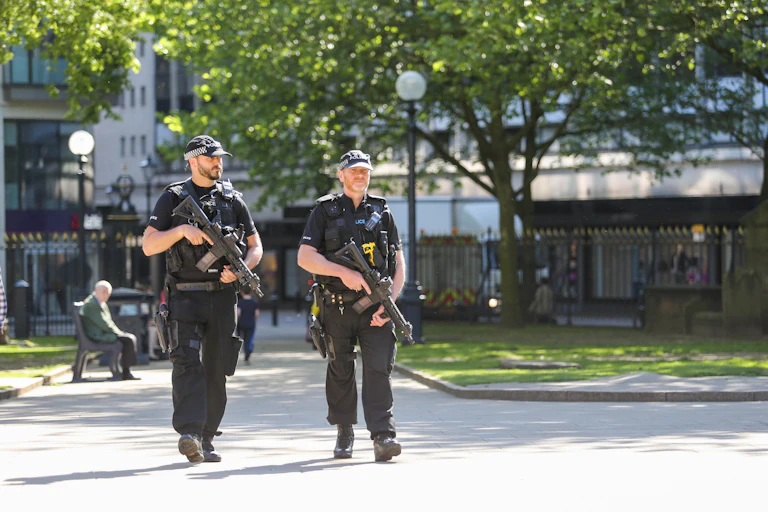 Two police officers carrying guns in park