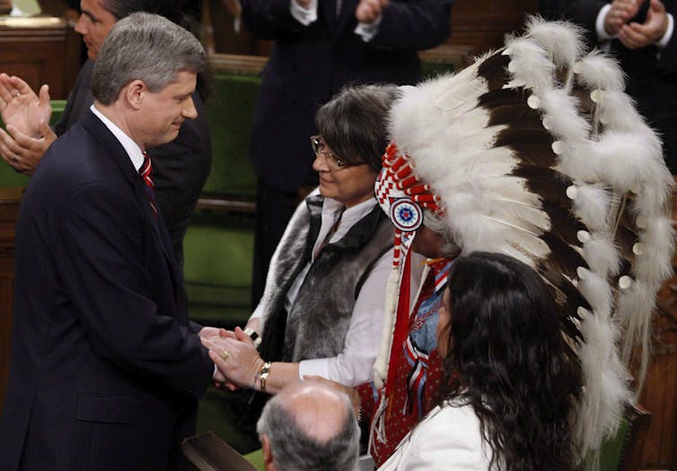 Former prime minister Stephen Harper shakes hands with former Inuit Tapiriit Kanatami president Mary Simon